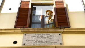 La casa natale di Savatore Satta con la targa icordo apposta sotto la finestra dalla quale si affaccia lo scrittore.